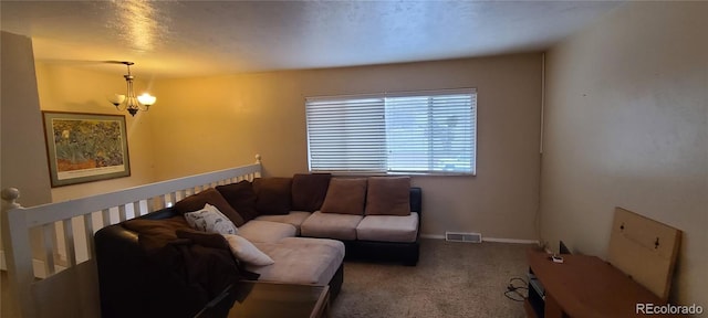 carpeted living room featuring a textured ceiling and a chandelier