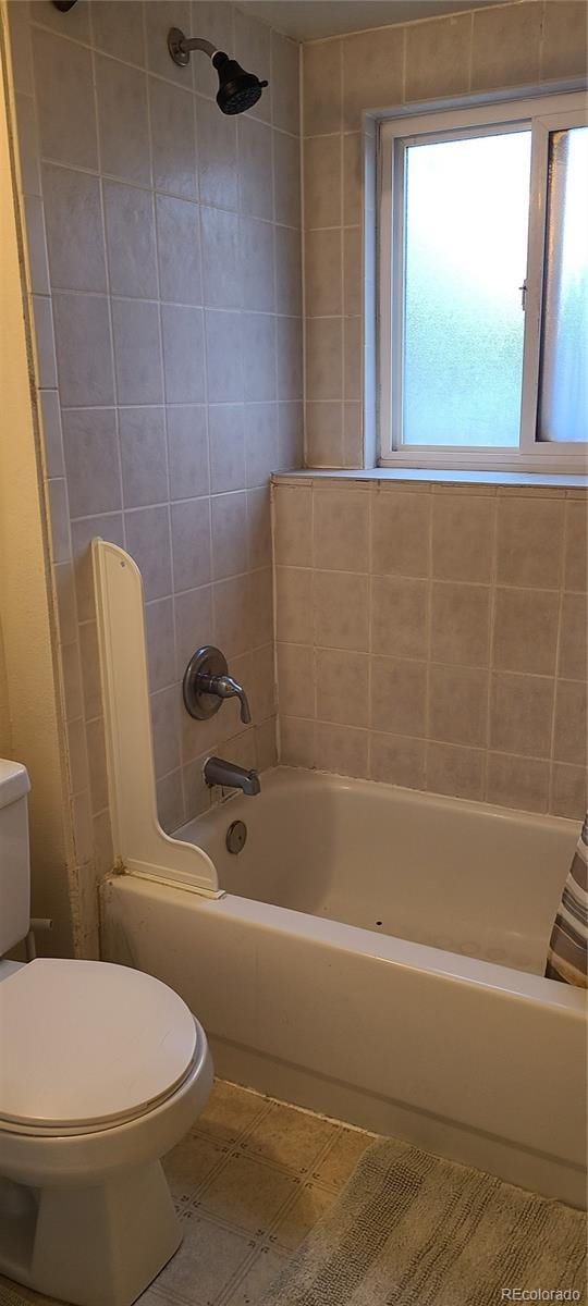 bathroom featuring tile patterned floors, toilet, and shower / bath combo with shower curtain