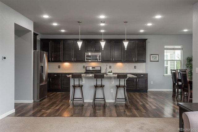 4025 Trail Stone Cir, Castle Rock, CO 80108 - kitchen featuring stainless steel appliances, a breakfast bar, backsplash, a center island with sink, and recessed lighting