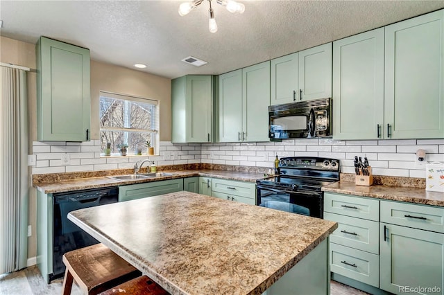 kitchen featuring green cabinets, sink, a kitchen island, and black appliances