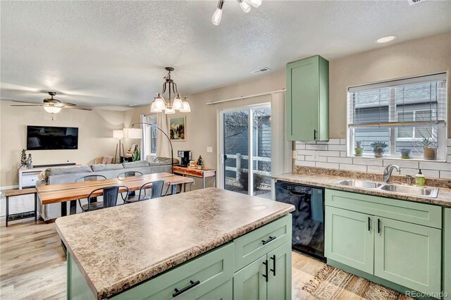 kitchen featuring sink, black dishwasher, green cabinets, decorative backsplash, and a kitchen island