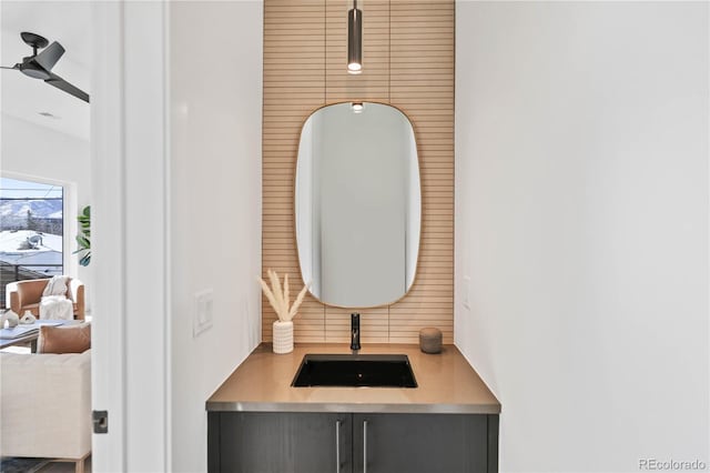 bathroom with backsplash, ceiling fan, and a sink