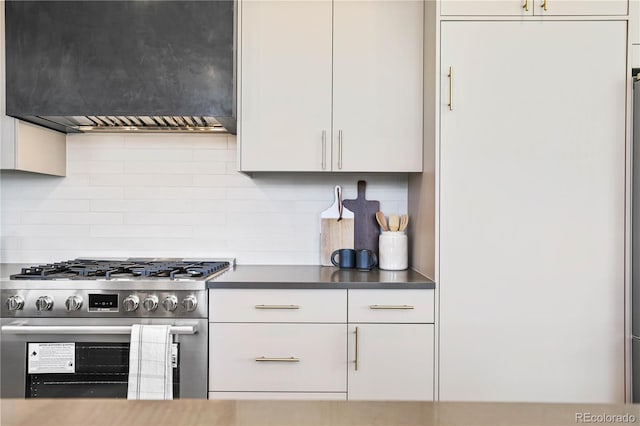 kitchen featuring custom exhaust hood, decorative backsplash, stainless steel range, and white cabinetry