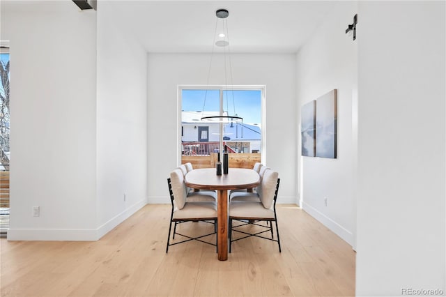 dining area featuring light wood-style flooring and baseboards