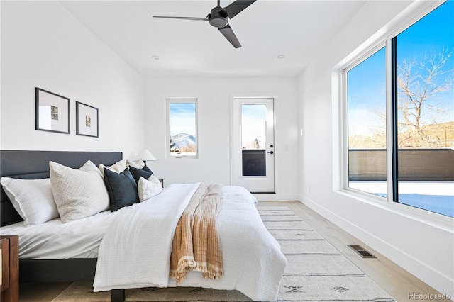 bedroom featuring light wood finished floors, visible vents, a ceiling fan, and baseboards