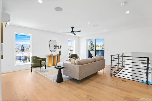 living room featuring light wood-style flooring, recessed lighting, and baseboards