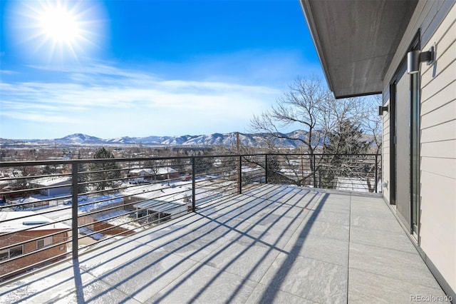 snow covered back of property with a mountain view