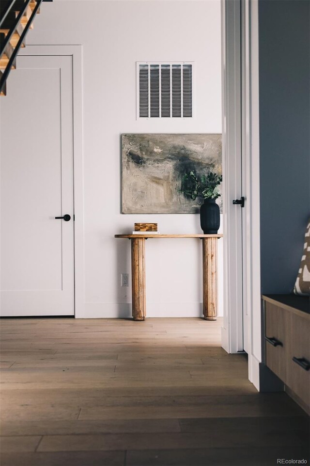 corridor featuring wood finished floors and visible vents