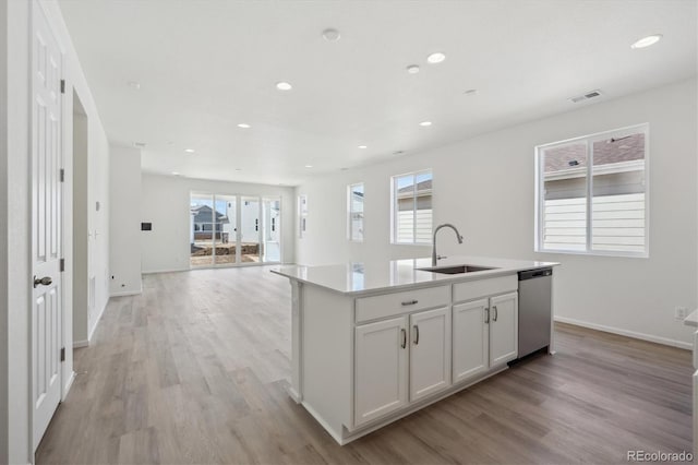 1306 Sienna Peak Cir, Erie, CO 80516 - kitchen featuring a kitchen island with sink, a sink, stainless steel dishwasher, and light wood finished floors