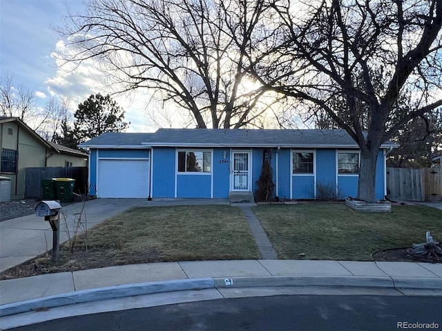 ranch-style home featuring an attached garage, driveway, fence, and a front yard