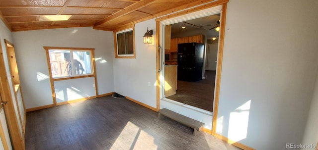 empty room featuring a ceiling fan, vaulted ceiling, baseboards, and wood finished floors