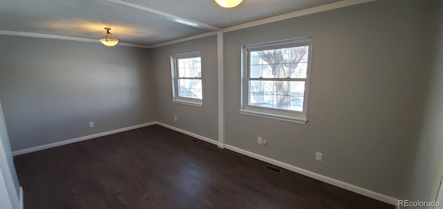 empty room featuring baseboards, crown molding, visible vents, and dark wood-type flooring