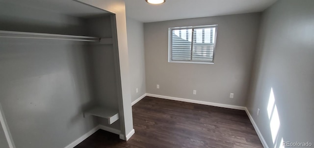 unfurnished bedroom featuring baseboards and dark wood finished floors