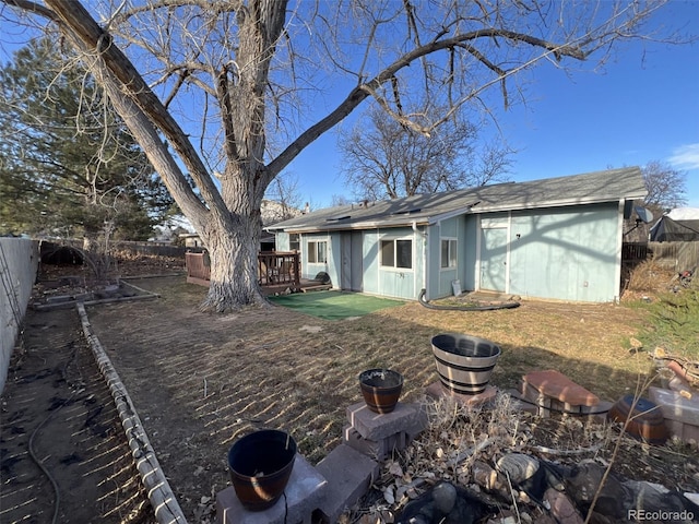 rear view of house featuring a fenced backyard and a deck