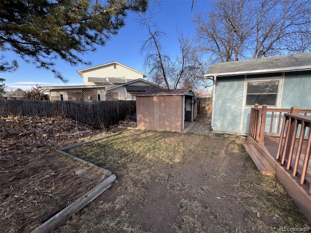 view of yard with a storage shed, fence, and an outbuilding