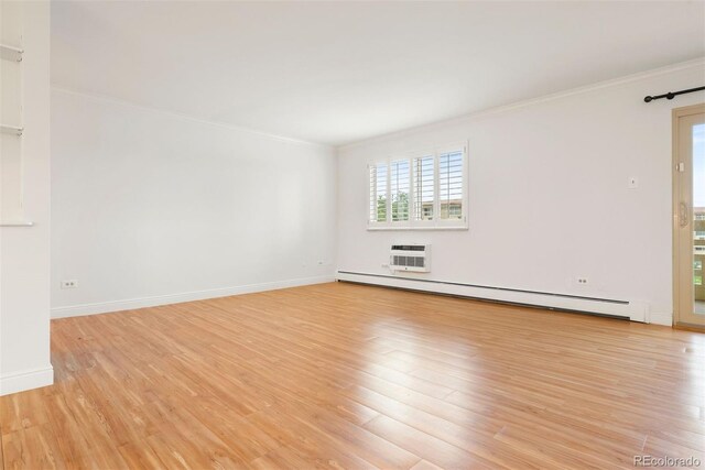 695 S Alton Way Unit 9C, Denver, CO 80247 - spare room with baseboard heating, crown molding, plenty of natural light, and light wood finished floors