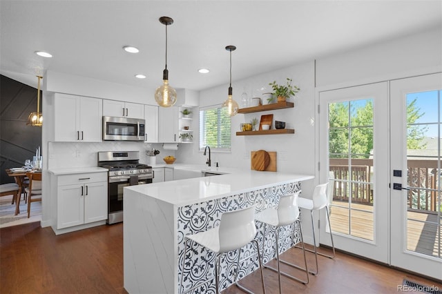 3357 Holly Hock Ct, Castle Rock, CO 80109 - kitchen with appliances with stainless steel finishes, open shelves, white cabinets, light countertops, and a peninsula