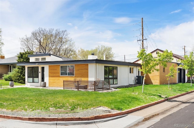 401 S Ivy St, Denver, CO 80224 - view of front of house featuring central AC unit, a front lawn, and a chimney