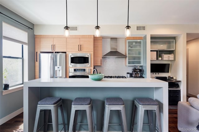 3420 W 32nd Ave Unit 203, Denver, CO 80211 - kitchen with stainless steel appliances, wall chimney range hood, a breakfast bar, and light countertops