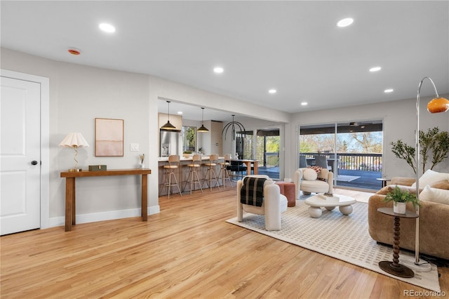 living area with light wood-style floors, baseboards, and recessed lighting