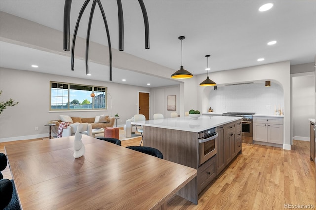 kitchen with light countertops, open floor plan, recessed lighting, and stainless steel appliances