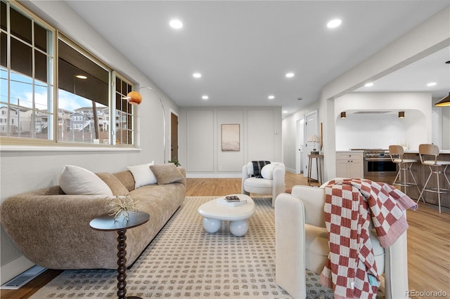 living room with recessed lighting and light wood-style flooring