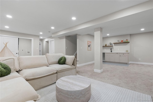 living room featuring stairs, light carpet, indoor wet bar, baseboards, and recessed lighting