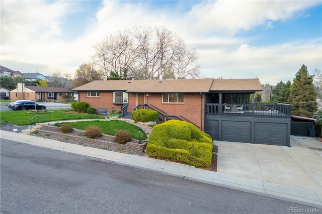 ranch-style house with an attached garage, concrete driveway, a front lawn, and brick siding