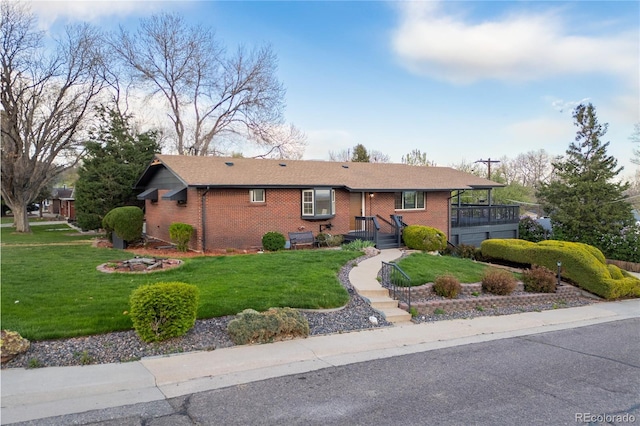 ranch-style house featuring a front yard and brick siding