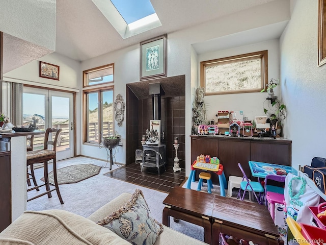 interior space featuring plenty of natural light, a wood stove, and a skylight