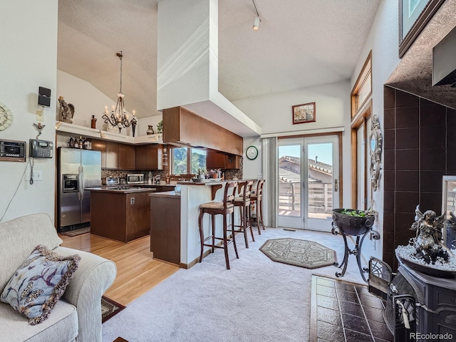 kitchen featuring a center island, a kitchen breakfast bar, light hardwood / wood-style floors, kitchen peninsula, and stainless steel appliances