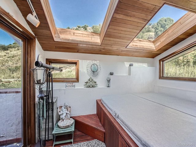 interior space with lofted ceiling with skylight and wood ceiling