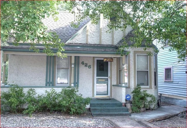 426 E Bijou St, Colorado Springs, CO 80903 - view of front facade with stucco siding, a shingled roof, and a porch