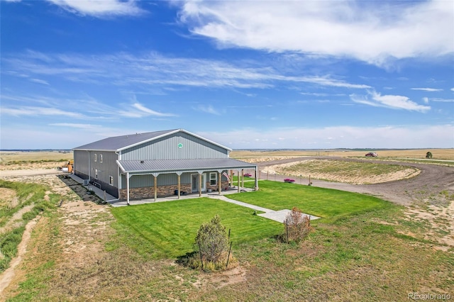 exterior space featuring a patio, a lawn, and a rural view