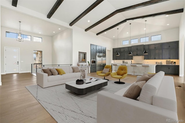 1877 Spring Bloom Dr, Windsor, CO 80550 - living room featuring high vaulted ceiling, an inviting chandelier, a wealth of natural light, beamed ceiling, and light wood-style floors