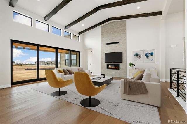 1877 Spring Bloom Dr, Windsor, CO 80550 - living room with baseboards, high vaulted ceiling, wood finished floors, beamed ceiling, and a fireplace