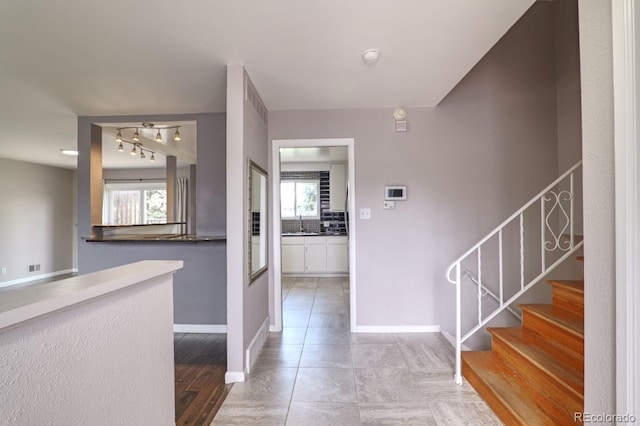 entryway featuring stairway, baseboards, plenty of natural light, and light tile patterned floors