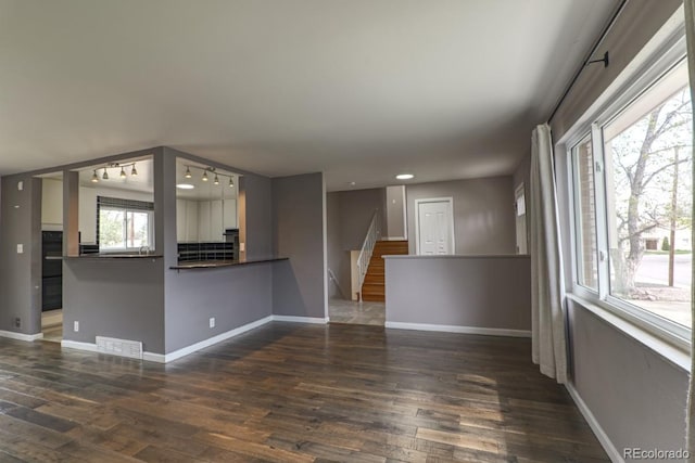 unfurnished living room featuring visible vents, dark wood finished floors, stairs, baseboards, and recessed lighting