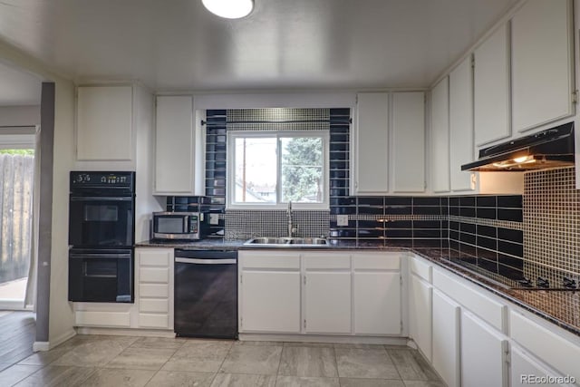 kitchen featuring dark countertops, a sink, white cabinetry, under cabinet range hood, and black appliances