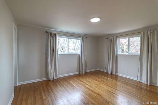 unfurnished room featuring baseboards, a healthy amount of sunlight, and light wood-style flooring