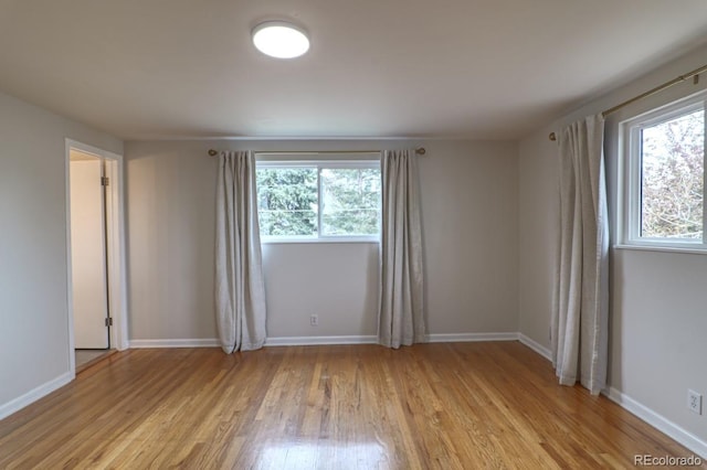 spare room with light wood-type flooring and baseboards