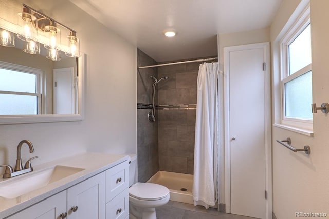 bathroom featuring vanity, toilet, tile patterned floors, and tiled shower