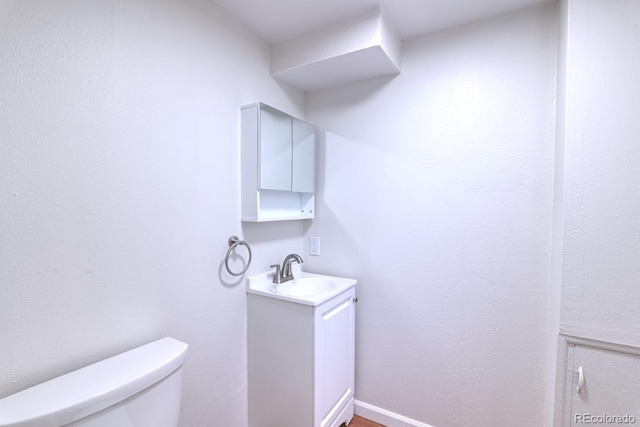 half bathroom with vanity and toilet