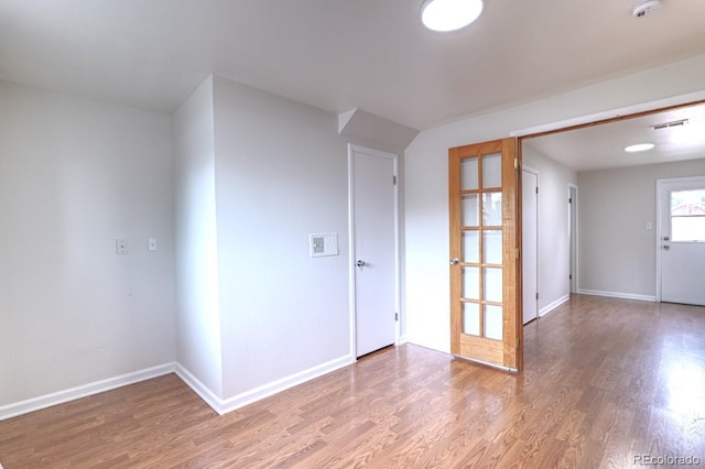 spare room featuring baseboards, visible vents, and light wood-type flooring