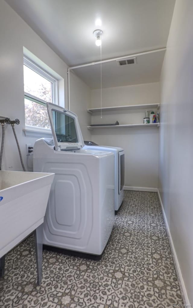 laundry area with laundry area, visible vents, washer and dryer, baseboards, and tile patterned floors