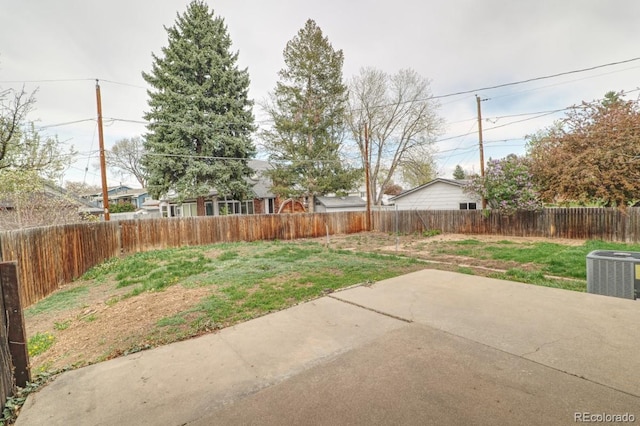 view of yard featuring a fenced backyard, a patio area, and central AC