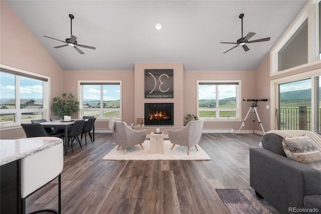 251 Grand Elk Way, Granby, CO 80446 - living area featuring a ceiling fan, high vaulted ceiling, dark wood-style flooring, a warm lit fireplace, and a baseboard radiator