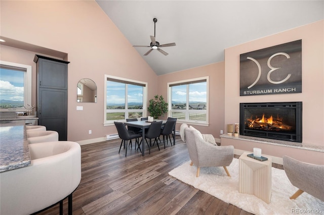 251 Grand Elk Way, Granby, CO 80446 - living area with high vaulted ceiling, a ceiling fan, dark wood finished floors, a glass covered fireplace, and a baseboard radiator