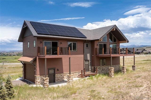 251 Grand Elk Way, Granby, CO 80446 - back of house featuring a balcony, roof mounted solar panels, a garage, and a mountain view