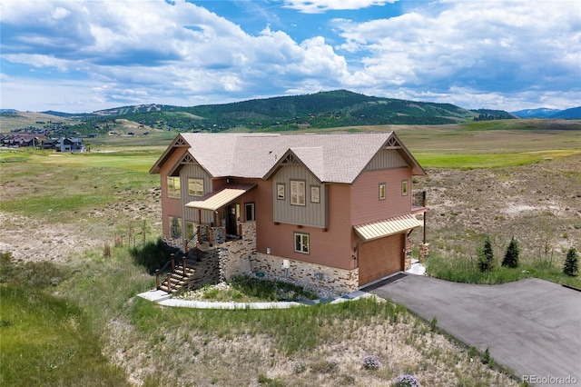 251 Grand Elk Way, Granby, CO 80446 - view of front of home featuring a mountain view, stone siding, an attached garage, and asphalt driveway